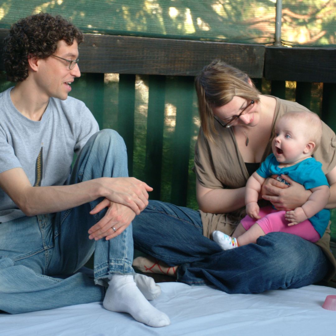 Man and woman with baby sitting on a deck at the original RIE® center in Los Angeles during RIE Parent Infant Guidance™ Class